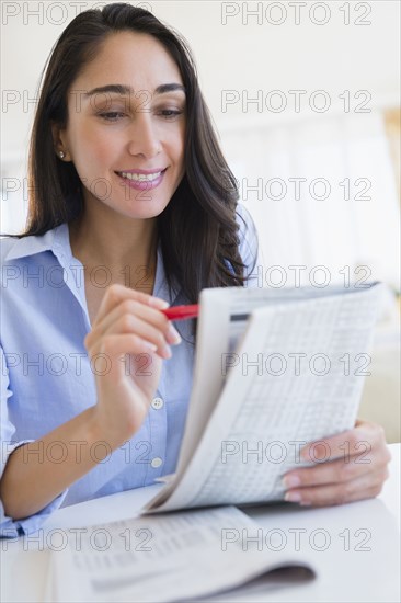 Caucasian businesswoman reading newspaper