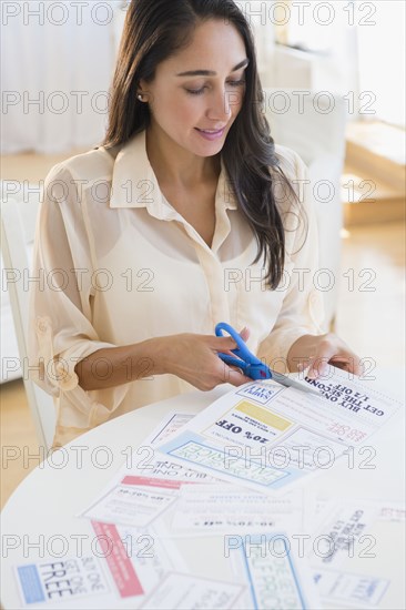 Caucasian woman clipping coupons