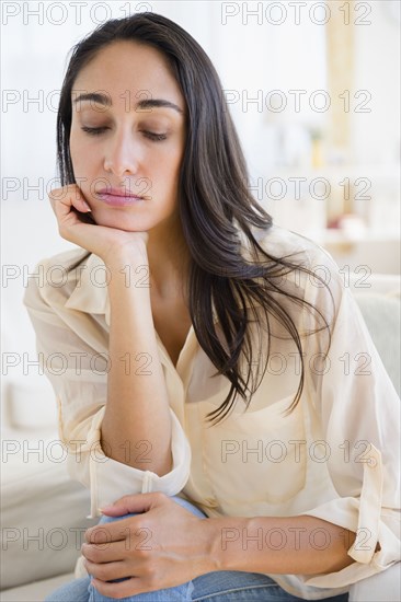 Caucasian woman resting chin in hand