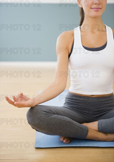 Caucasian woman meditating on exercise mat