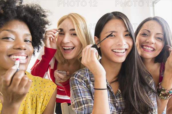 Smiling women applying make up