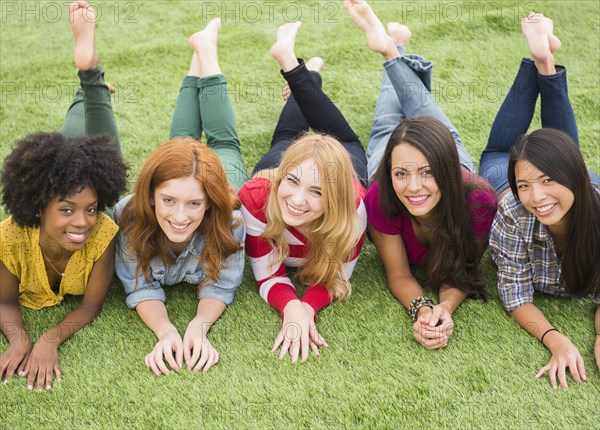 Smiling women laying in grass together