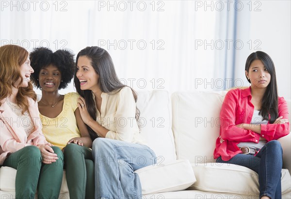 Woman excluded from conversation on sofa
