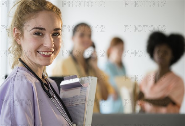 Smiling nurse holding clipboard in hospital