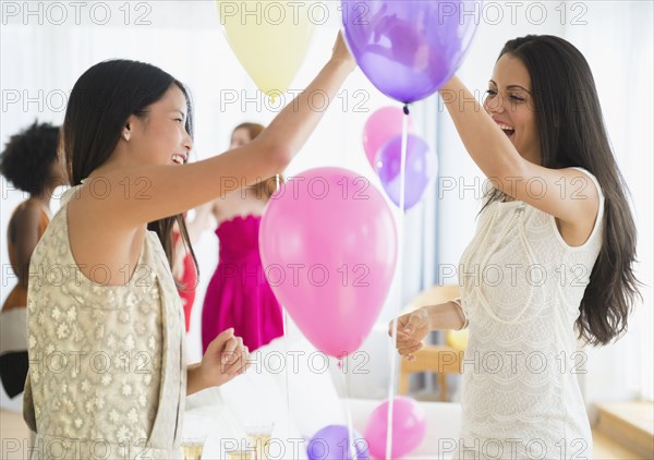 Women playing with balloons at party