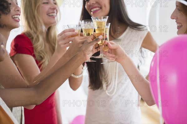 Women toasting each other with champagne at party