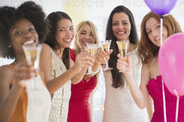 Women toasting each other with champagne at party