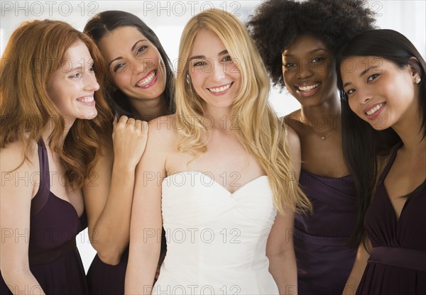 Bridesmaids helping bride into wedding dress