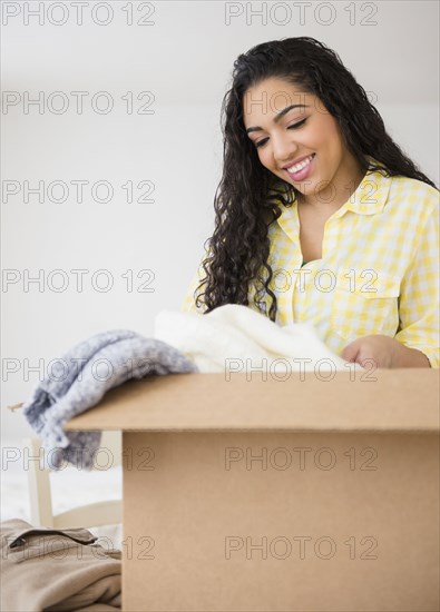 Hispanic woman unpacking cardboard box