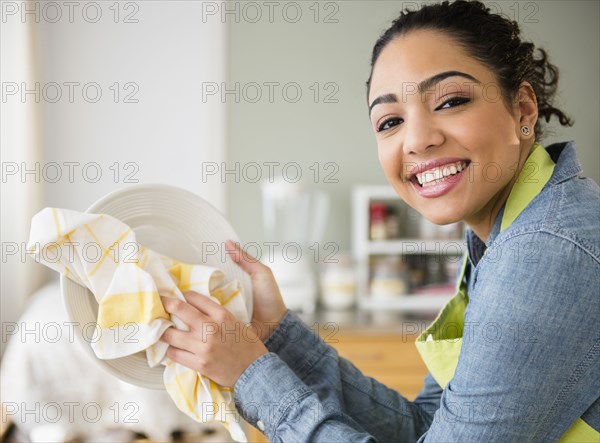 Hispanic woman wiping plate