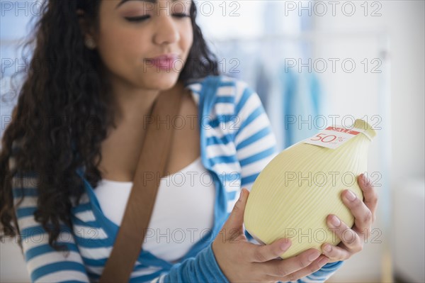 Hispanic woman examining vase for sale