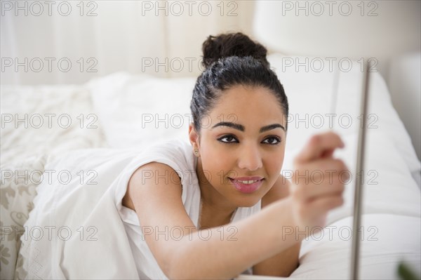 Hispanic woman turning on light