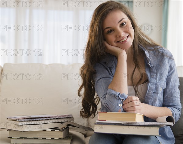 Hispanic girl studying on sofa