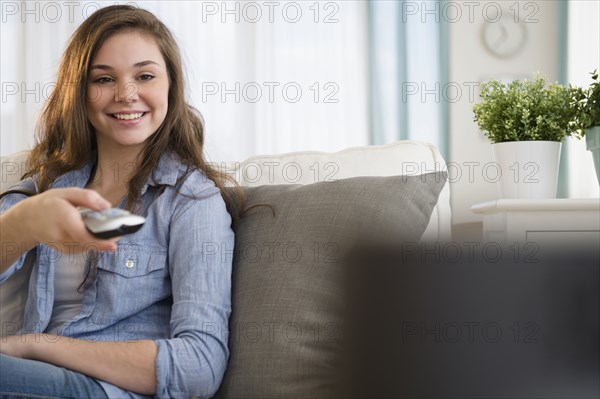 Hispanic girl watching television on sofa