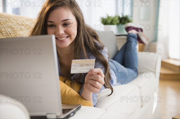 Hispanic girl shopping on sofa