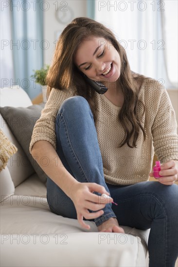 Hispanic girl painting her toenails