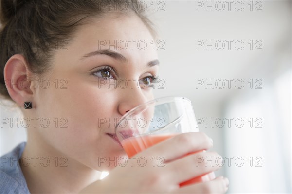 Hispanic girl drinking glass of juice