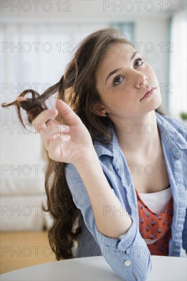 Hispanic girl twirling her hair