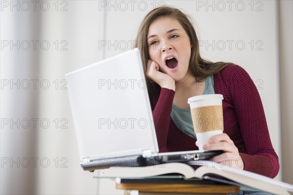 Hispanic girl yawning at desk