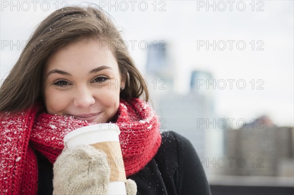 Hispanic girl drinking coffee in snow