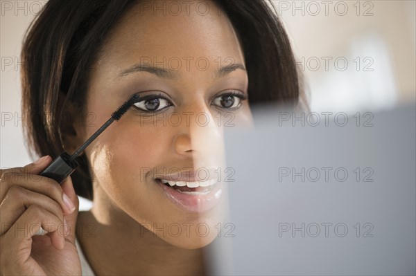 African American woman applying makeup