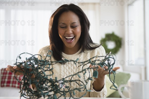 African American woman untangling Christmas lights