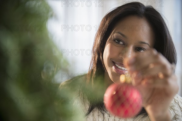 African American woman decorating Christmas tree