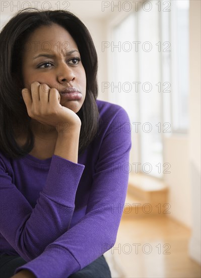 Anxious African American woman frowning