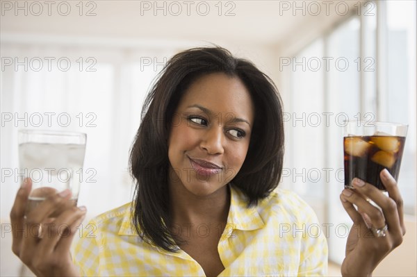 African American woman choosing water or soda