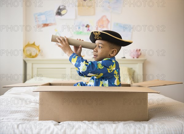 African American boy playing in cardboard box