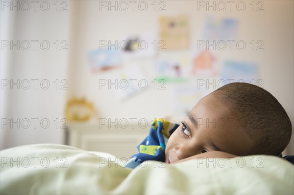 African American boy laying in bed