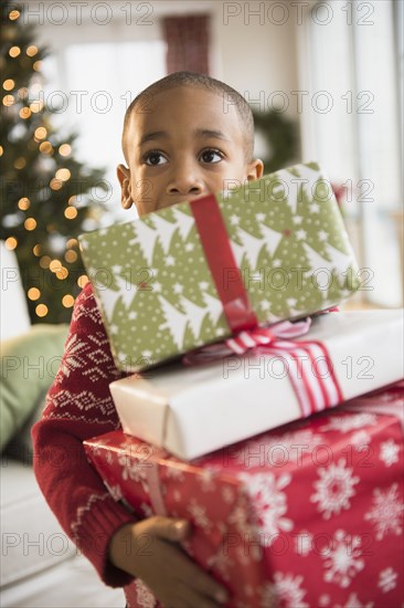 African American boy carrying Christmas presents