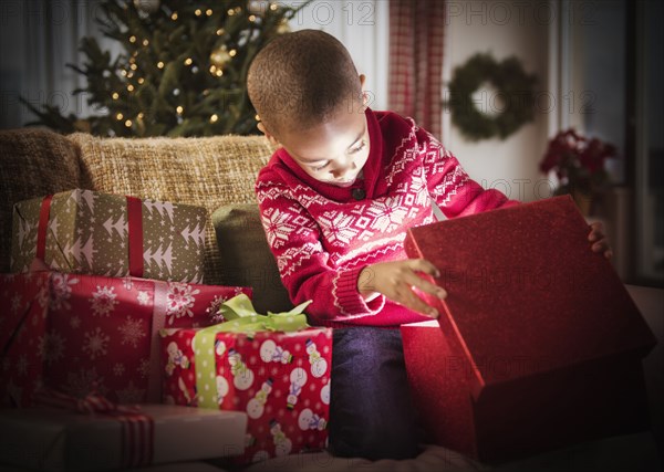 African American boy opening Christmas presents