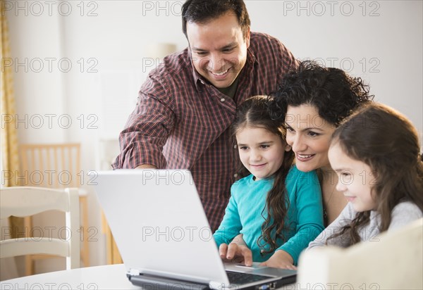 Family using laptop together at table