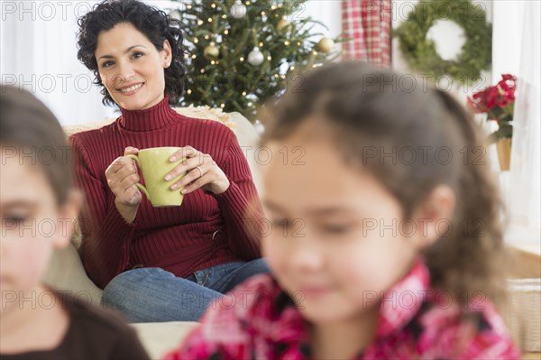 Mother watching daughters in living room