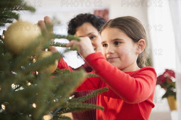 Mother and daughter decorating Christmas tree