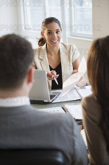 Businesswoman talking with clients at desk