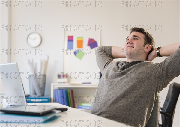 Businessman relaxing at desk in office