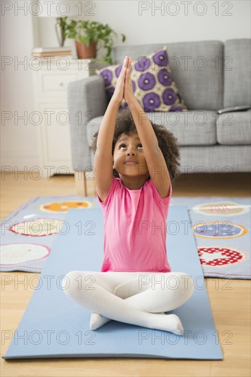 African American girl practicing yoga in living room