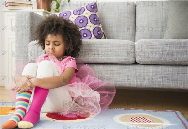 African American girl frowning in living room