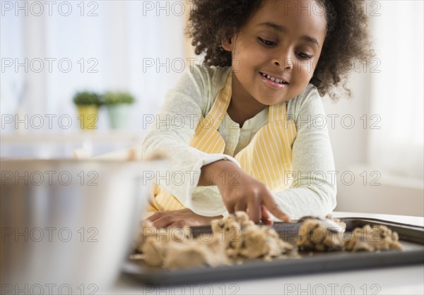 African American girl baking cookies in kitchen