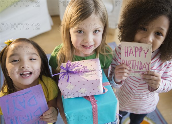 Girls holding presents and cards at birthday party