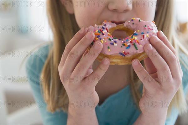 Caucasian girl eating donut