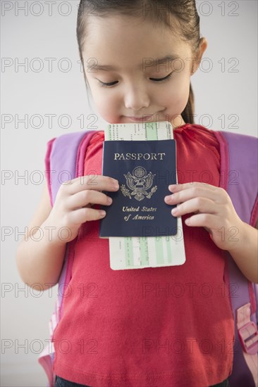 Asian girl holding airplane ticket and passport
