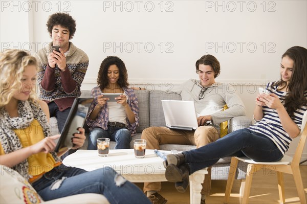 Friends using technology in living room