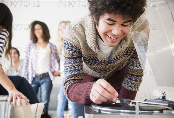 Man putting on record in living room