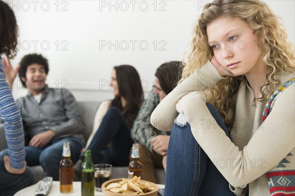 Woman sitting apart from friends