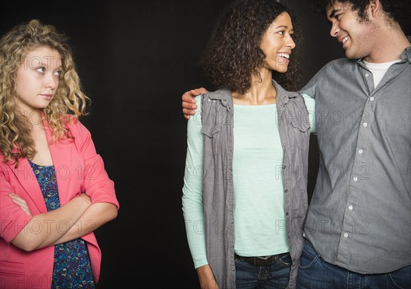 Smiling couple ignoring friend