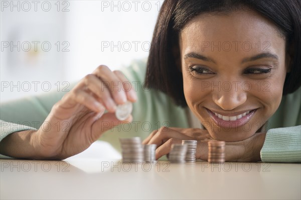 Mixed race woman stacking coins