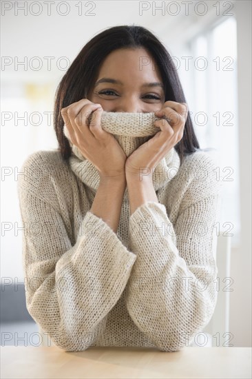 Mixed race woman wrapped in sweater